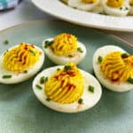 Spanish Deviled Eggs with smoked paprika and chives on an easter plate